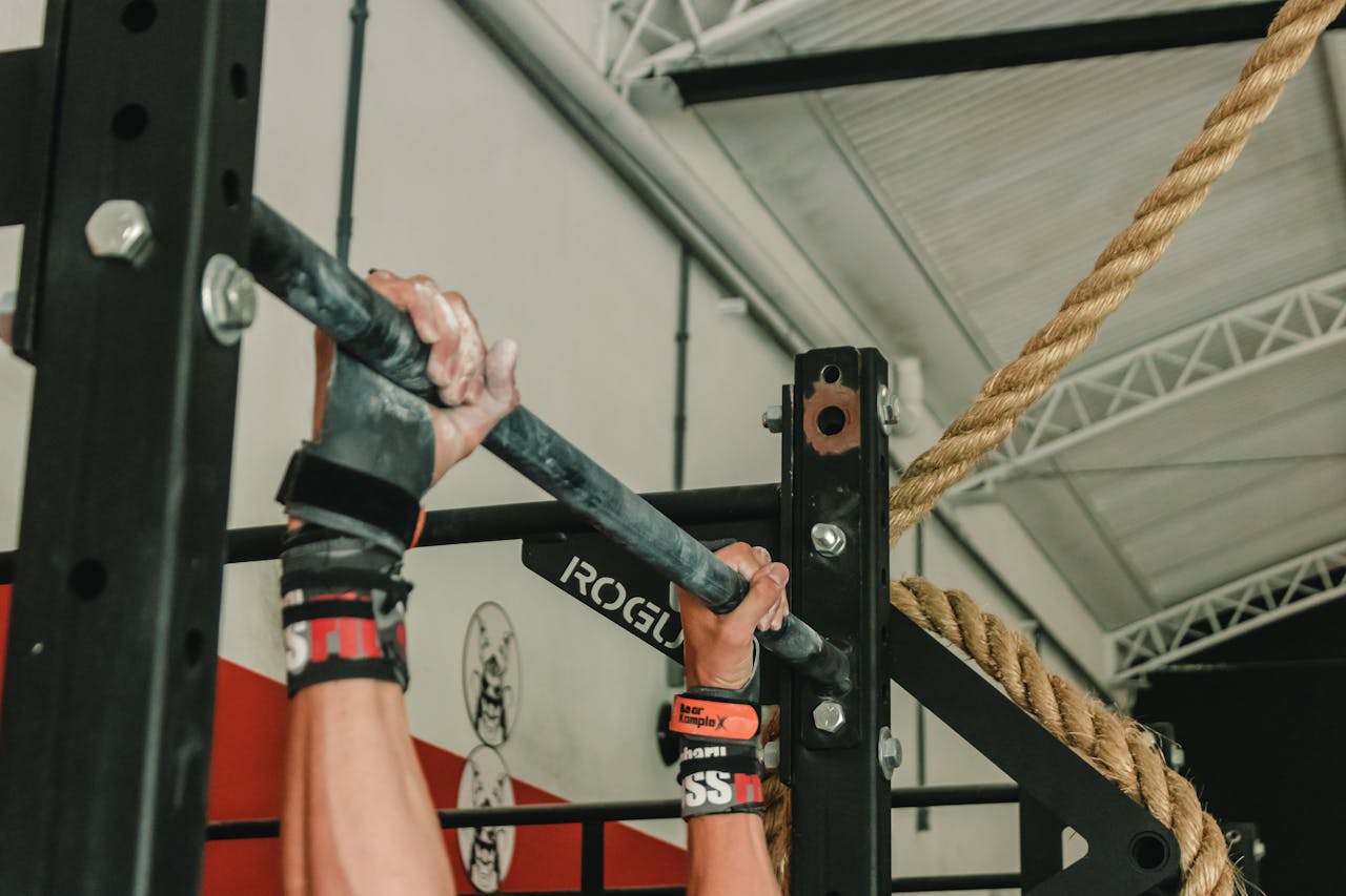 Close-up of hands gripping pull-up bar during an intense gym workout session.